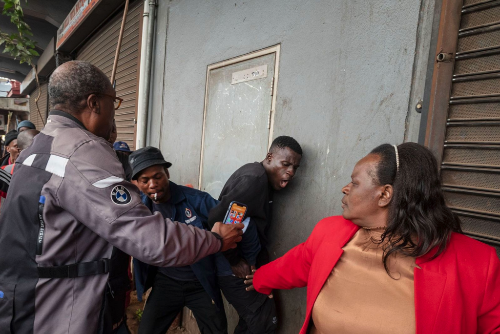 A man who was suspected by protesters of being a foreign national squeezed through the crowd to safety after being confronted during the march. A small group of people was shielded from assault by individuals who intervened and escorted them to safety as protesters marched through the streets of the Johannesburg CBD, South Africa, on Tuesday, June 30, 2026. (Photo: Leon Sadiki)