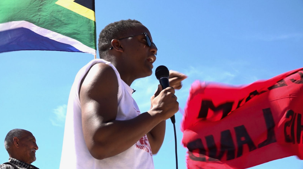 Leading affordable housing activist Nkosikhona Swartbooi speaks at a Reclaim the City Rally. (Photo: Supplied)