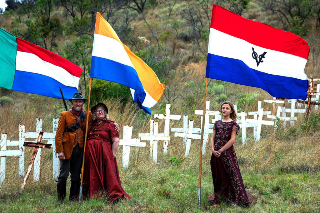Afrikaners dressed in traditional clothing carry flags during a memorial for killed South African farmers at the Witkruis (White Cross) Monument on a private farm on October 4, 2025 in Ysterberg near Polokwane, South Africa. The monument commemorates about 2800 of the alleged 4000 white farmers who have been killed in the country since 1994. Every year farmers from around the country gather to plant new crosses at the memorial. South Africa has one of the highest murder rates in the world, suffering more than 26,000 murders last year, although official statistics do not indicate that white farmers are more likely to be the victims of violent crime than other populations. (Photo: Per-Anders Pettersson / Getty Images)
